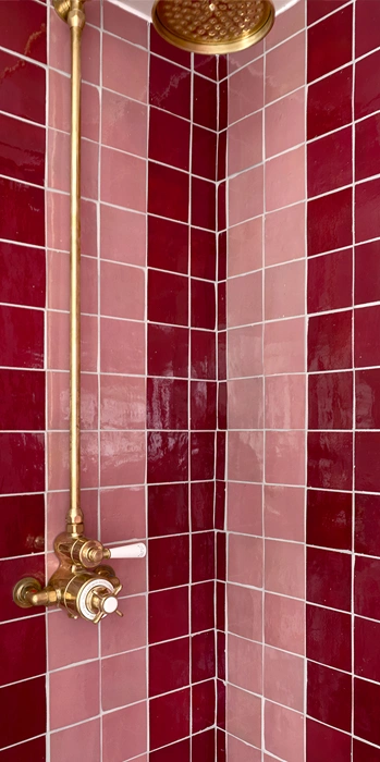Shower walls featuring pink and bourdeaux coloured zellige
